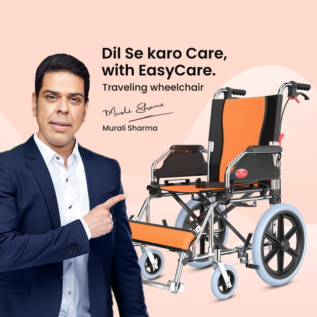 Actor Murali Sharma endorsing an EasyCare traveling wheelchair with orange and black upholstery and a lightweight chrome frame.