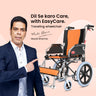 Actor Murali Sharma endorsing an EasyCare traveling wheelchair with orange and black upholstery and a lightweight chrome frame.